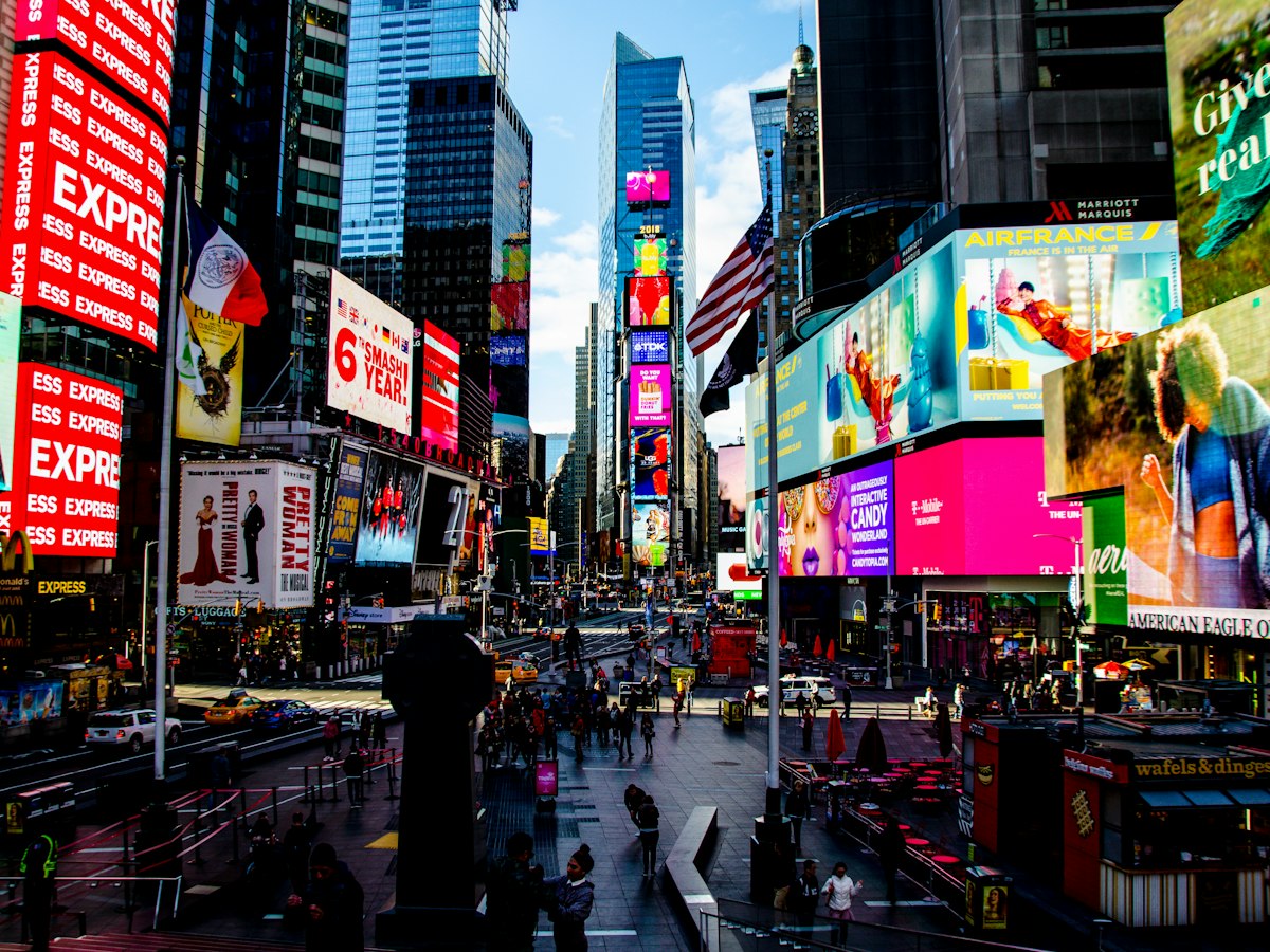 Bright digital billboards lining a busy city square